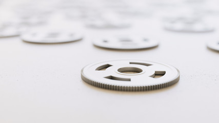 chrome gears scattered on a white surface with shallow depth of field