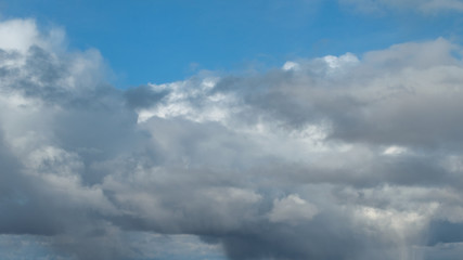 Naklejka na ściany i meble Fluffy,swirling clouds in the blue sky.