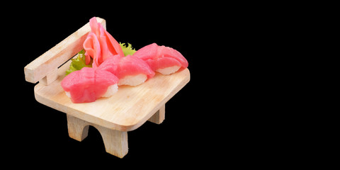 Japanese Cuisine - Nigiri Sushi on wood plate on black background and space for text
