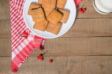 Biscuits, milk, red napkin, Christmas decor with free space for text. Top view