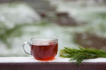 Photo sur Plexiglas Theé glass mag of hot tea in winter Park on a wooden table