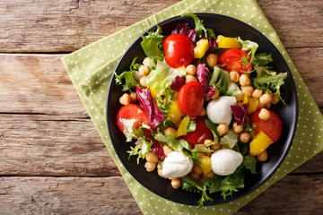 Healthy food: salad with chickpeas, vegetables and mozzarella cheese close-up. horizontal top view