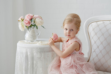 Cute little girl in a pink dress. Portrait on a white background in a romantic vintage style