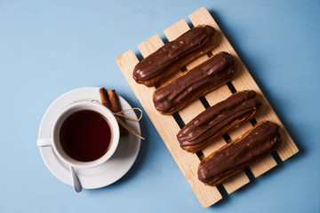 Cup of hot tea with cinnamon steak and french chocolate eclairs