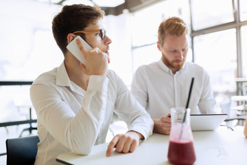 Confident busy businessman working on tablet