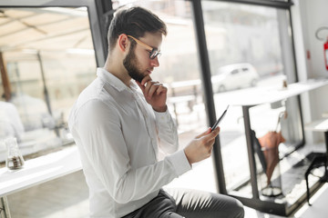 Businessman wearing glasses using tablet