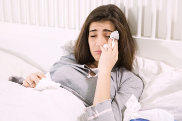 Ill woman in bed holding handkerchief