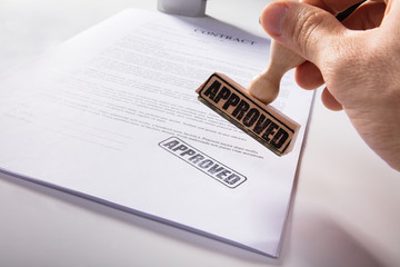 Person's Hand Stamping Approved On Contract Paper