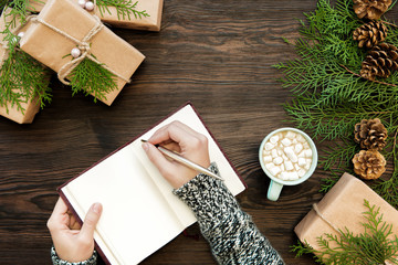 female hand writes Christmas letter 