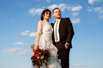 The bride and groom on the background of the sky.