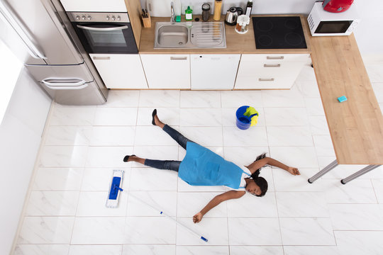 Unconscious Housewife Lying On Kitchen Floor