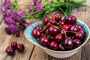 Mellow sweet cherry in bowl on wooden table