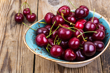 Fototapeta na wymiar Mellow sweet cherry in bowl on wooden table