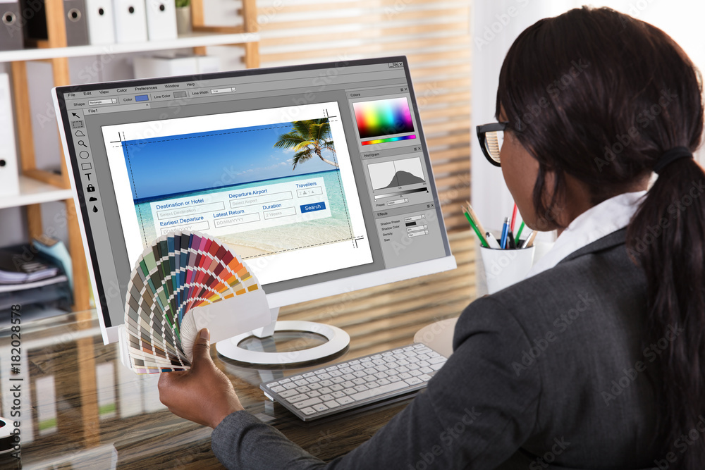Poster female designer holding colorful swatch working on computer