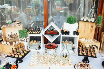 Dinner table with salty snacks, cheese put on the wooden boxes