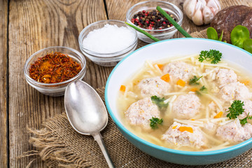 Soup with meatballs for dinner on wooden background