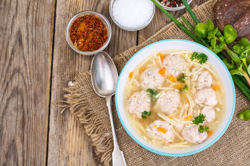 Soup with meatballs for dinner on wooden background
