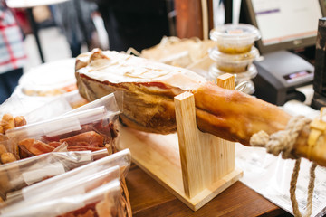 Large ham stands on the wooden table outside