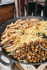 Large frying pans with vegetables stand on gas outside