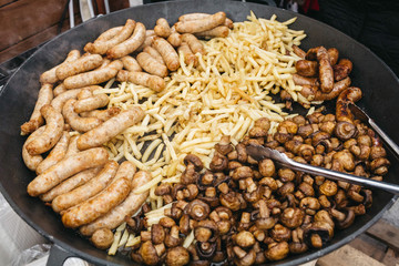 Large frying pans with vegetables stand on gas outside