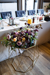 Steel golden vase with beautiful violet and yellow roses stands in the hall
