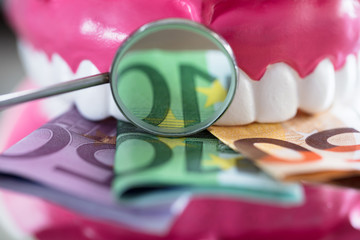 Close-up Of Denture With Banknote