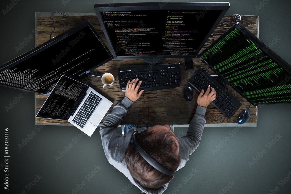 Fototapete Hacker Hacking Multiple Computers On Desk