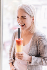 Laughing woman with a colorful beverage