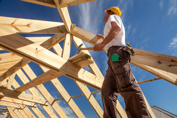 roofer builder working on roog structure of building on construction site - obrazy, fototapety, plakaty