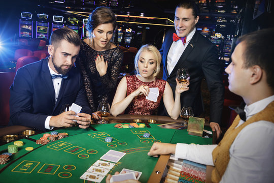 Group of rich people is playing poker in the casino