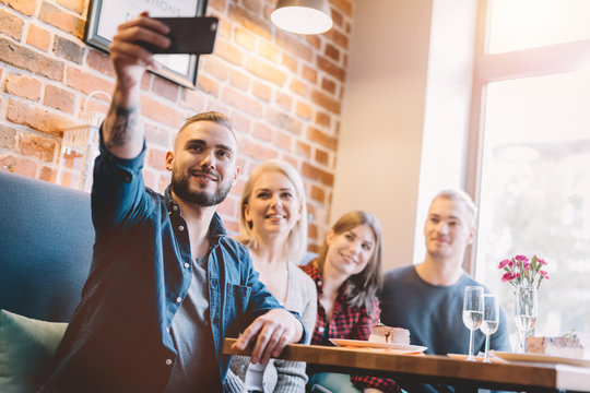 Group of people taking a selfie together in a restaurant.