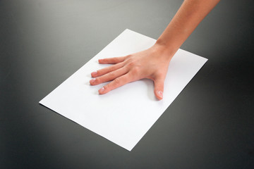 Female hands with paper on a black background. studio isolate.