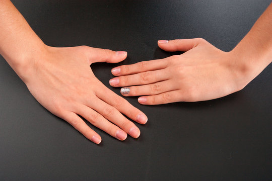 female hands manicure on a black background. studio isolate.