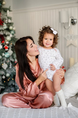 Merry Christmas celebration. Beautiful family in a pajamas near the Christmas tree. Christmas miracles. Happy New Year