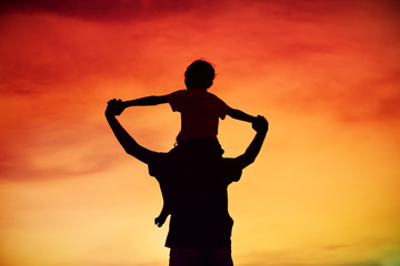 Fototapeta premium father and son play on sunset sky