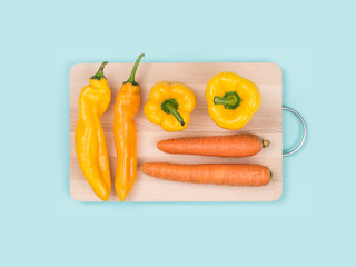 Fresh peppers and carrots on a cutting board