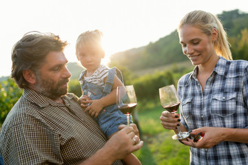 Wine grower family in vineyard before harvesting