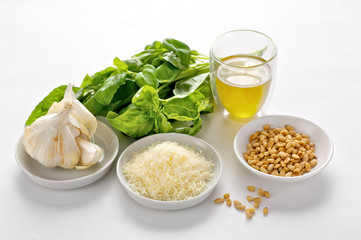 Zutaten für die Zubereitung von Pesto: Pinienkerne, Parmesan, Knoblauch, Olivenöl, Basilikum
