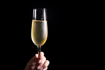 Woman hand holding glasses of champagne on the black background