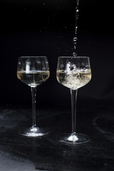 two glasses with champagne. On a black background