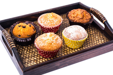 Sweet homemade cupcakes on wooden tray, white background