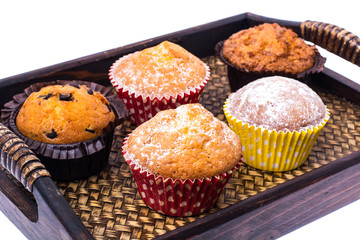 Sweet homemade cupcakes on wooden tray, white background