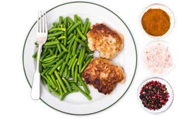 Plate with green beans and meat on white background, top view