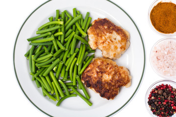 Plate with green beans and meat on white background, top view
