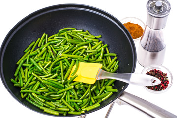 Fried pods of green beans in frying pan