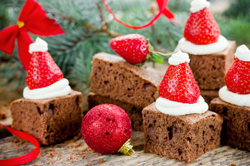 Santa hat brownie, Christmas dessert, chocolate pieces with strawberry and cream