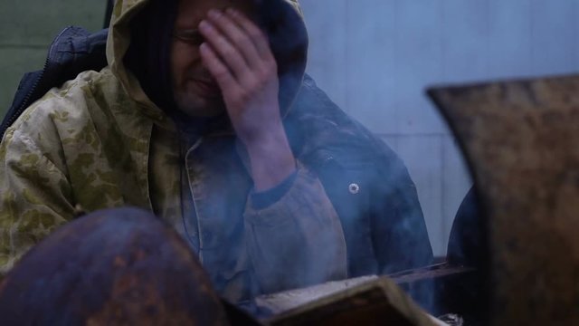 portrait of Homeless man in front of a fire, close up