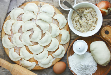 Homemade dumplings with meat stuffing, raw dumplings on a wooden table
