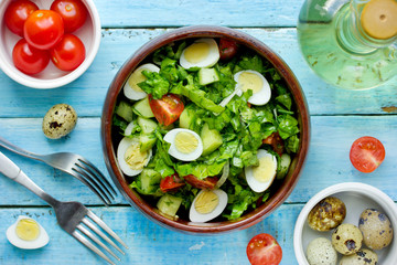 Green vegetable salad with cherry tomatoes quail eggs and olive oil dressing