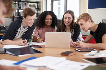 Group Of College Students Collaborating On Project In Library